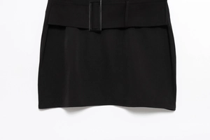 Detail of a chic black mini dress featuring a matching wide belt and sleek waist tailoring