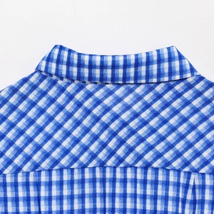 Macro view of the blue and white plaid fabric texture and neckline stitching detail