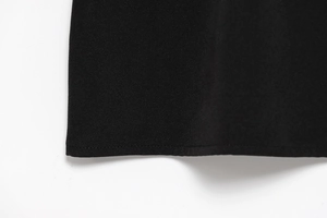 Detail of the neat stitching and smooth hemline on black sleeveless summer dress fabric