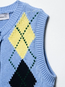 Detail of argyle knit vest neck ribbing with blue, yellow and navy diamond pattern