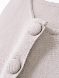 Detail of soft knit fabric texture and elegant fabric-covered buttons on casual top