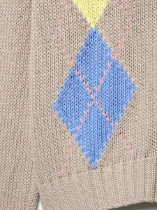 Detail of khaki chunky knit cardigan featuring colorful argyle pattern and texture