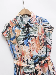 Détail de la robe à imprimé floral tropical avec ceinture nouée et boutonnage
