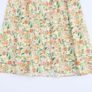 Detailed macro view of the colorful floral print dress with wooden front buttons