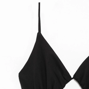 Close-up of the delicate V-neckline and slim spaghetti straps on a black summer dress