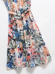 Détail d'une robe maxi fleurie avec col en V, boutonnage frontal et ceinture à nouer