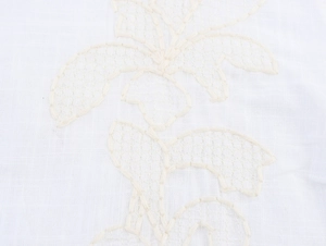 Close-up of white French lace embroidery and high-quality linen fabric detail