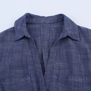 Detail of navy blue shirt collar with chest pockets and textured fabric finish