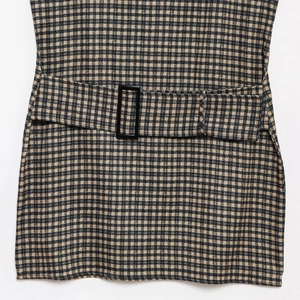 Detail view of brown gingham dress waist featuring a matching belt and black buckle