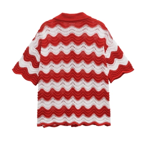 Close-up of red and white wavy crochet knit fabric with hollow texture on short sleeve top
