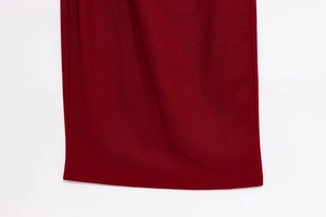 Detail of the dark red dress fabric showing high-quality stitching and smooth woven texture