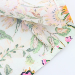 Detailed close-up showing precision stitching and floral print on white summer dress fabric