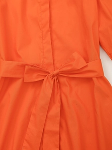 Gros plan détaillé sur la ceinture à nœud orange de cette robe d'été élégante et chic