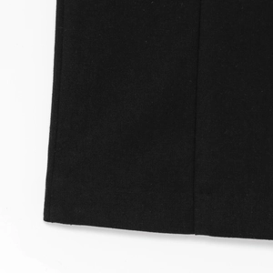 Detailed close-up of the black sleeveless dress showing high-quality stitching and fabric texture