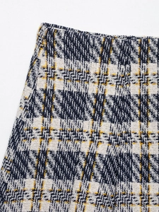 Vue macro du tissu en tweed tissé avec des fils texturés blancs, bleus et jaunes