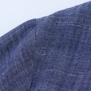Detail of dark blue woven fabric texture and premium double-stitched seams on the dress