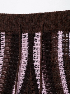 Detailed macro shot of a knitted polo shirt's waist with pink stripes and drawstring ties