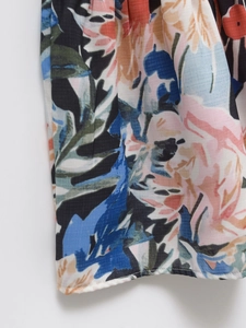 Gros plan du tissu à imprimé floral aux couleurs vives et détail d'ourlet piqué