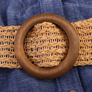 Detail of bohemian woven belt featuring a round wooden buckle on a summer midi dress