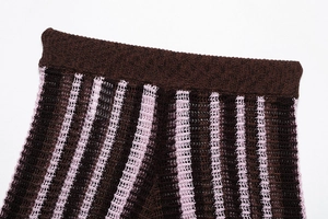 Detail of hollow-out knit fabric with pink and brown stripes and elastic ribbed waistband