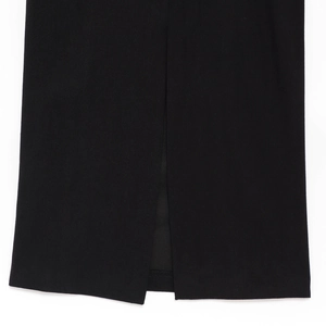 Detailed close-up of the elegant irregular hem with clean slit on this black dress