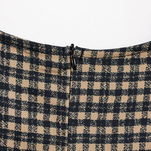 Macro shot of invisible zipper and textured khaki plaid fabric on the sleeveless dress