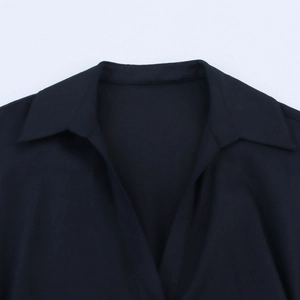 Detail eines klassischen schwarzen Reverskragens mit tiefem V-Ausschnitt am Kleid