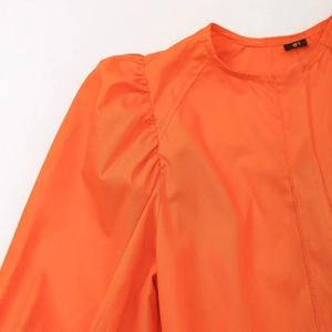Élégante robe orange vif à manches bouffantes avec col rond et détails plissés