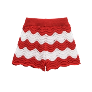 Detail of red and white wave pattern knit shorts with scalloped edges and textured mesh