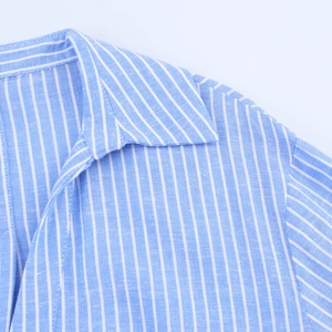 Detailed view of the sharp collar and shoulder seams on blue striped shirt dress