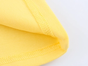 Detail of yellow cotton fabric showing double-needle stitching and inner overlock seam