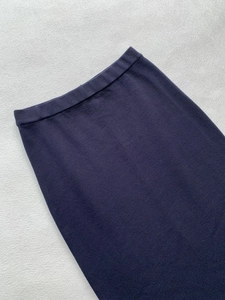 Detail view of navy blue knit midi skirt showing elastic waist and smooth fabric texture