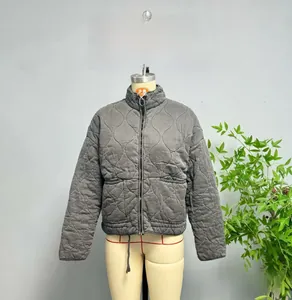 Close-up of diamond quilted texture and front zipper on grey puffer jacket