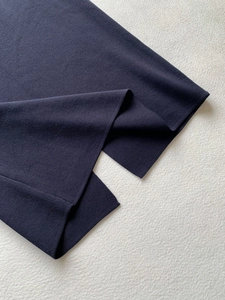 Detailed macro view of high-quality navy blue knit skirt with elegant side slit detail