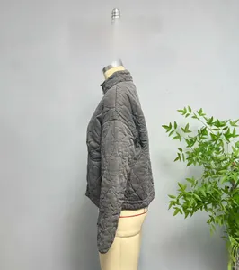 Detail view of charcoal gray quilted jacket with diamond patterns and standing collar