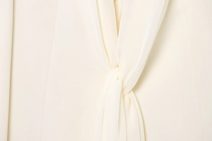Detailed close-up of cream blazer knot design featuring premium chiffon drape texture