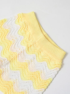 Detail of yellow and white wavy striped knit fabric with openwork crochet texture