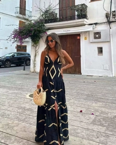 Detail of black backless maxi dress with gold geometric patterns and side slit