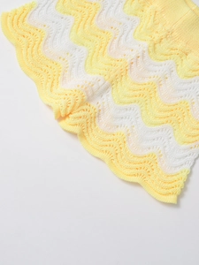 Detail of yellow and white wave pattern knit fabric with crochet hollow texture