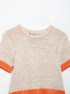Close-up of cream knit short-sleeve top with chunky texture and orange contrast stitching