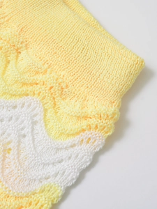 Detail of light yellow and white wavy hollow knit texture on summer knitwear set