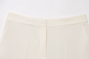 Close-up of cream white trouser waist with premium woven texture and neat stitching details