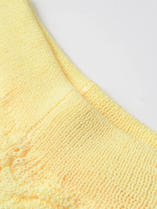 Close-up detail of light yellow knit fabric texture showing fine mechanical weaving patterns