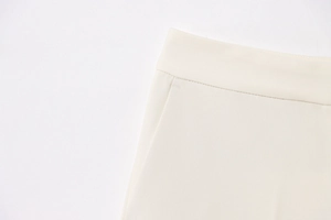 Detailed view of cream-colored blazer trousers with clean stitching and pocket seams