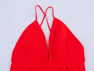 Détail de la robe rouge à col en V montrant les bretelles croisées dans le dos et l'encolure