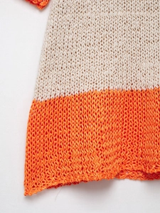 Detail of hollow knit mesh texture with beige and orange color-blocking design