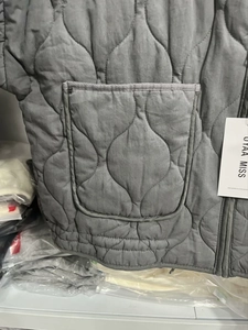 Close-up of water-drop quilted fabric texture with large square pocket and zipper
