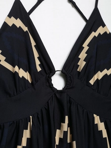 Detail of V-neckline with metal ring buckle and geometric pattern on black dress