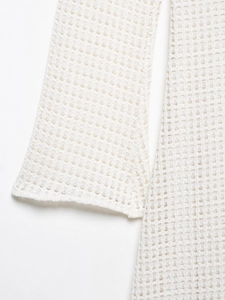 Close-up of white crochet midi dress showing intricate knit texture and side stitching
