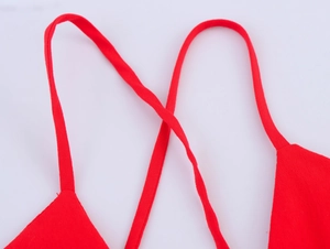 Détail de la robe midi rouge montrant les fines bretelles croisées et le tissu uni